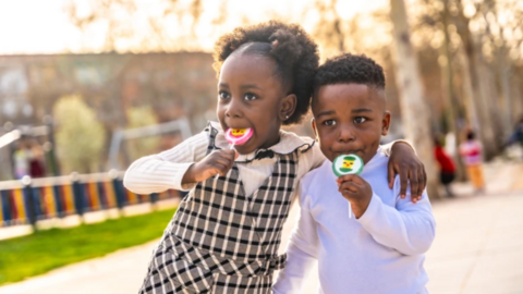 Two children eating lollipops