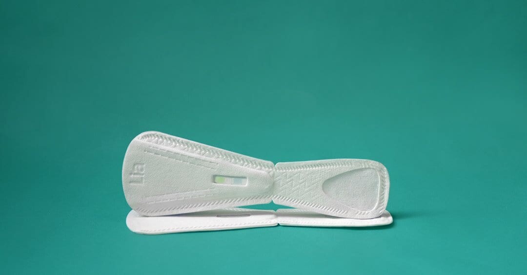 Photo of lia diagnostics pregnancy test against green background